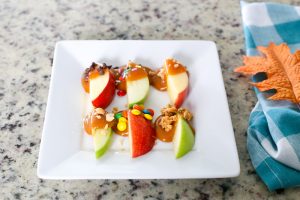 Surprise your kids this Fall with a basket full of Ingredients to make an Easy Kid-Friendly Caramel Apple Bar. Perfect for an afternoon snack or a special gift for teachers and neighbors!